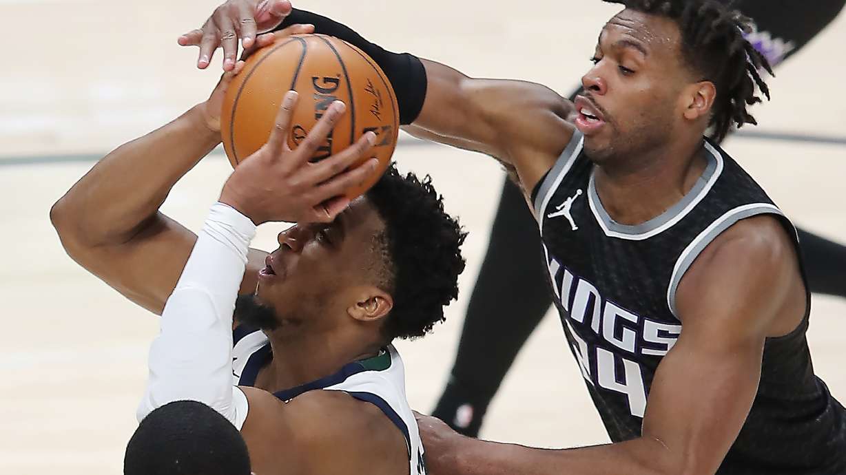 Utah Jazz guard Donovan Mitchell (45) powers up a shot with Sacramento Kings guard Buddy Hield (24) defending as the Utah Jazz and the Sacramento Kings play an NBA basketball game at Vivint Arena in Salt Lake City on Saturday, April 10, 2021.