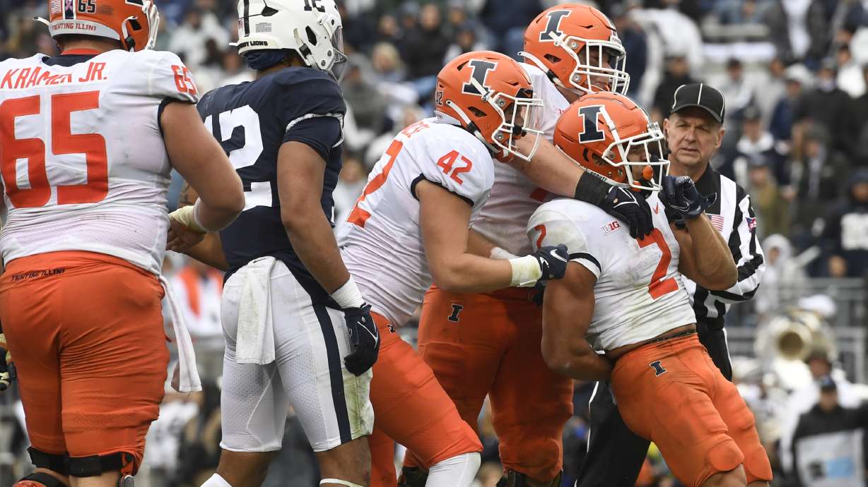 Illinois running back Chase Brown (2) celebrates with Michael Marchese (42) and Jack Badovinac after scoring on a second quarter touchdown run against Penn State during an NCAA college football game in State College, Pa., Saturday, Oct. 23, 2021.