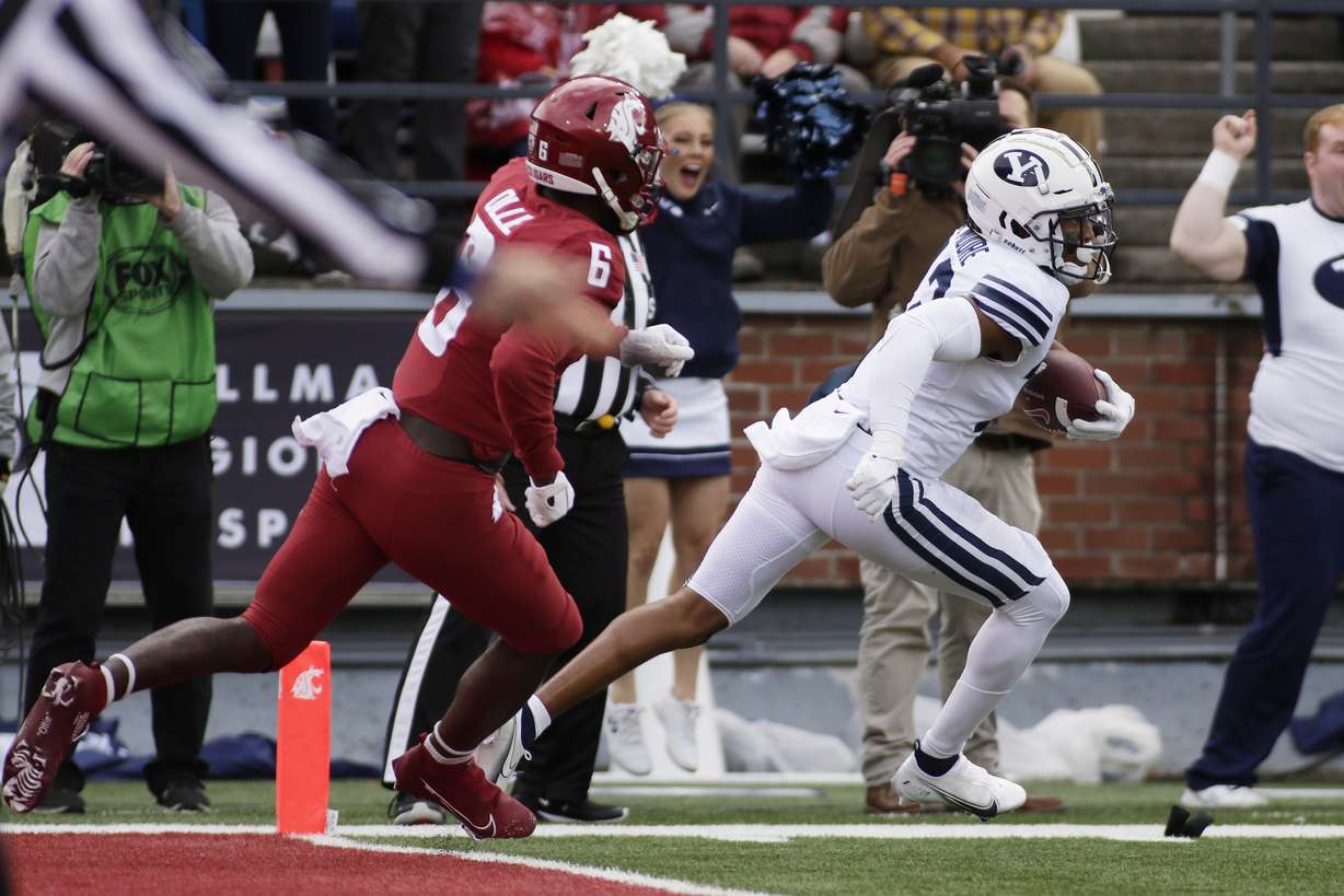 BYU defensive back Malik Moore, right, runs the interception he caught on a pass intended for Washington State wide receiver Donovan Ollie (6) out of the end zone during the first half of an NCAA college football game, Saturday, Oct. 23, 2021, in Pullman, Wash.
