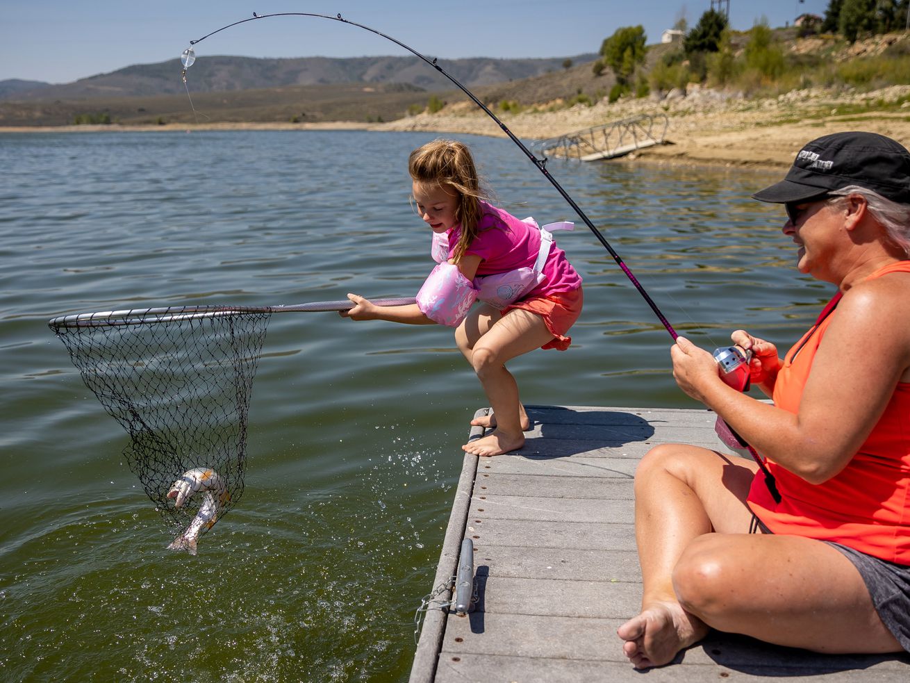 Presley Morse, 6, helps land a cutthroat trout while
fishing with her mother, Jill Gilson, at Scofield State Park on Aug. 27. It’s no secret — the outdoors are being
loved to death. And in the public land-rich states of the West,
campsites have seen an explosion in popularity over the last
decade.