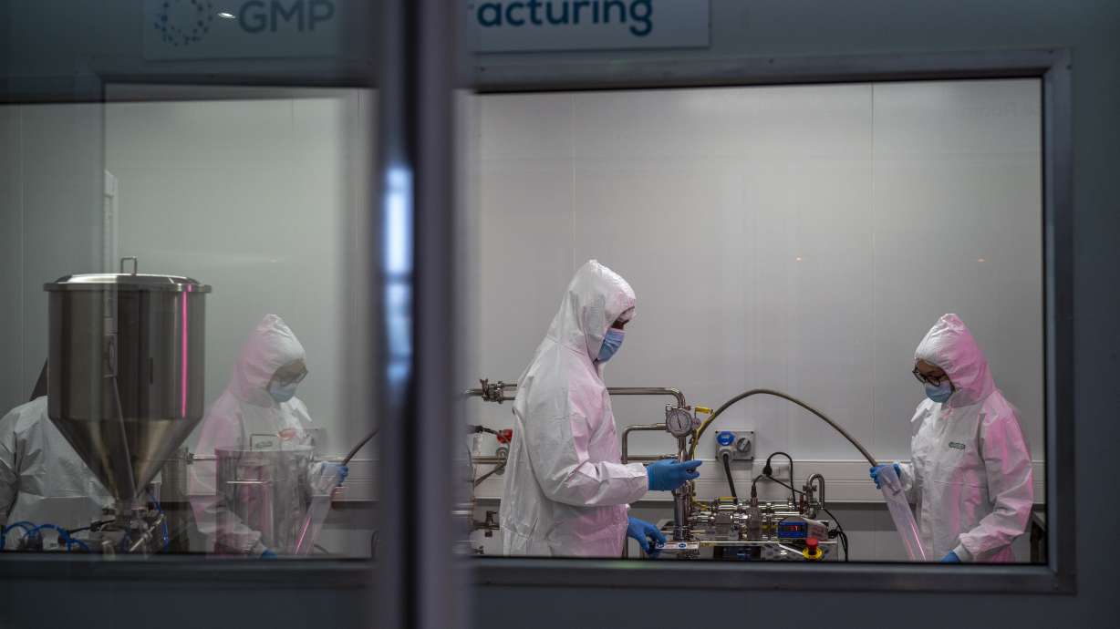 Scientists re-enact the calibration procedure of equipment at an Afrigen Biologics and Vaccines facility in Cape Town, South Africa, on Oct. 19. In a pair of warehouses converted into a maze of airlocked sterile rooms, young scientists are assembling and calibrating the equipment needed to reverse engineer a coronavirus vaccine.