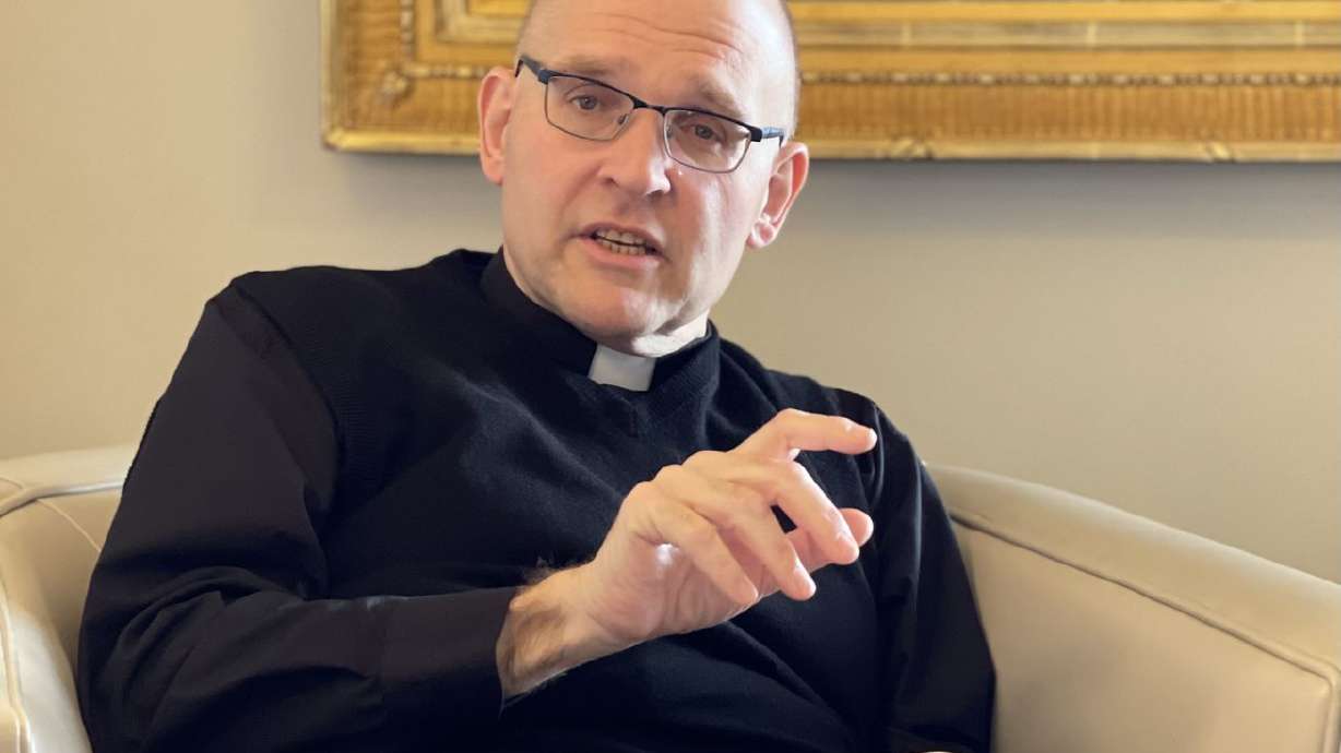 The Rev. Dr. Andrew Teal makes a point about a passage in the Doctrine and Covenants from his copy of the Latter-day Saint quadruple combination during an interview about the Oxford
chaplain’s upcoming BYU forum address at his residence in Provo on Monday.