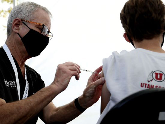 David McKay administers a COVID-19 vaccination to a 12-year-old boy at Rose Park Elementary in Salt Lake City on Sept. 22. The Utah Department of Health reported 2,152 new COVID-19 cases on Wednesday and 14 additional deaths from the virus.