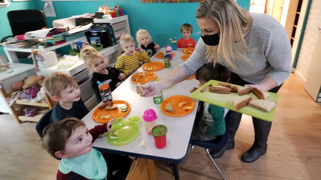 Amy McCoy serves lunch to preschoolers at her Forever Young Daycare facility, Monday, in Mountlake Terrace, Wash.