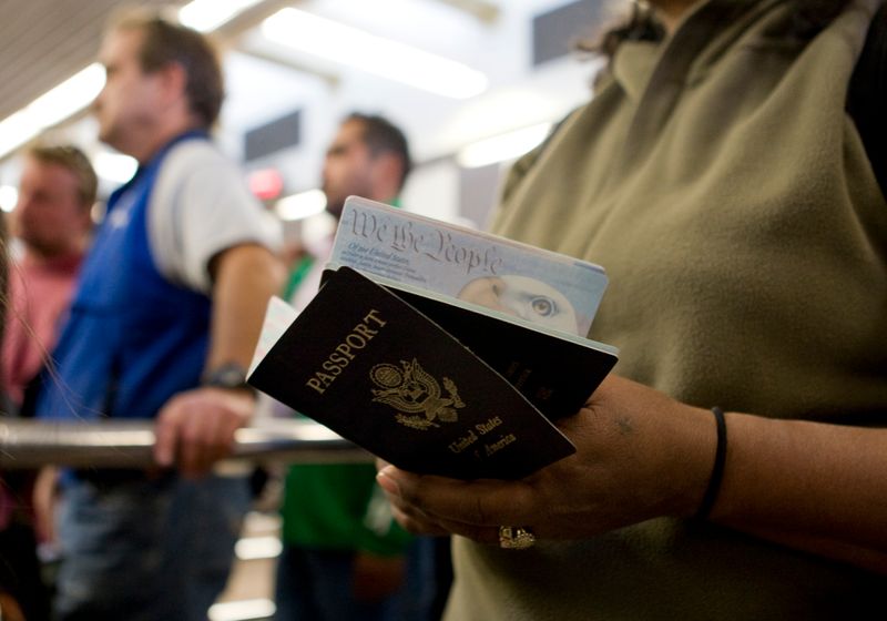 A pedestrian holds her and her child's passport in San Ysidro, California Jan. 31, 2008. The United States has issued its first passport with an "X" gender designation — a milestone in the recognition of the rights of people who don't identify as male or female — and expects to be able to offer the option more broadly next year, the State Department said Wednesday.