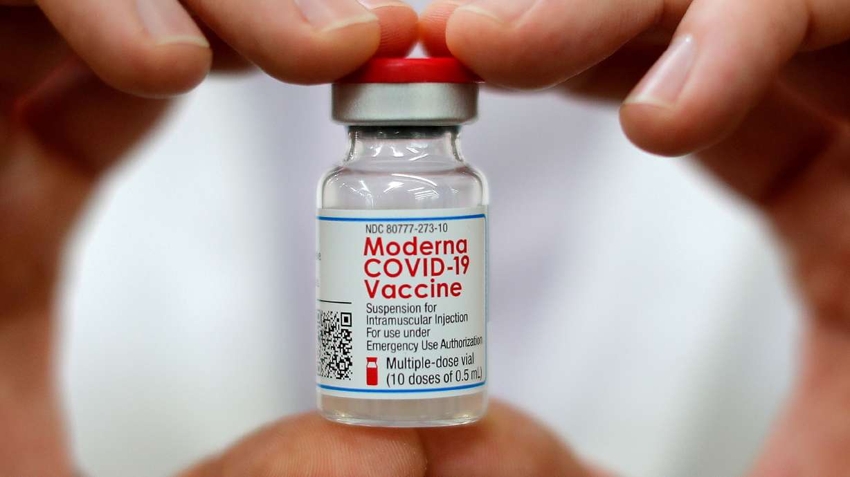 A Walmart pharmacist holds a vial of the Moderna coronavirus disease vaccine inside a Walmart department store in West Haven, Connecticut, U.S., February 17, 2021. Moderna's COVID-19 vaccine could start to be used in children and teens in the United States within weeks, its chief executive said