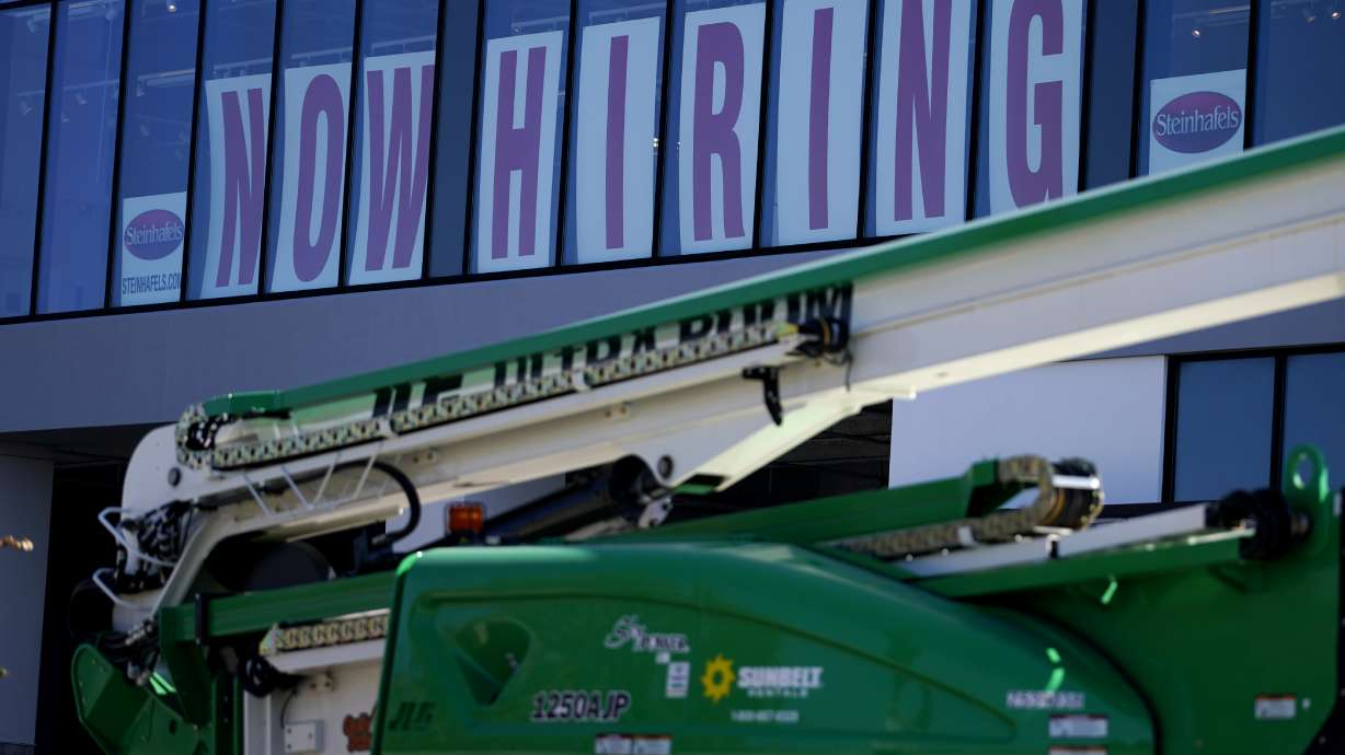 A hiring sign is displayed at a furniture store window on Sept. 17, in Downers Grove, Ill. Unemployment claims dropped 6,000 to 290,000 last week, the third straight drop, the Labor Department said Thursday.