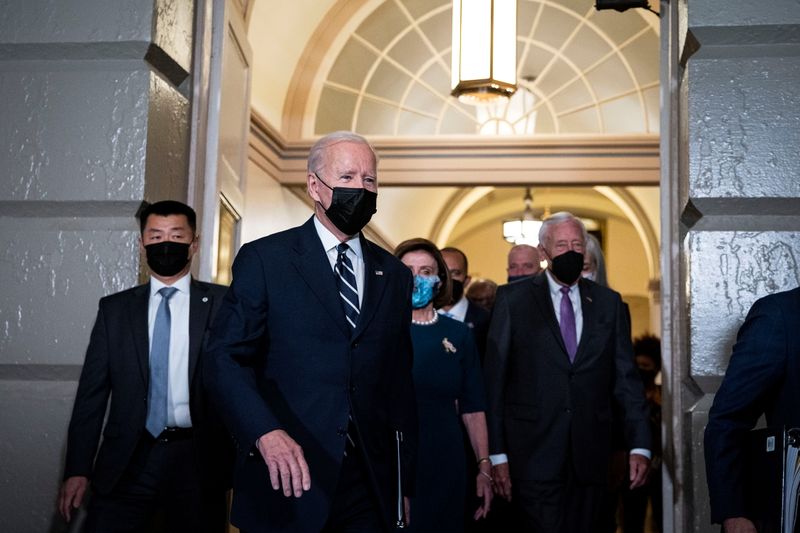President Joe Biden is escorted by House Speaker Nancy Pelosi, D-CA, as he arrives at the U.S. Capitol Thursday. He made a last-minute trip to Congress on Thursday to push a new $1.75 trillion framework for economic and climate change spending.
