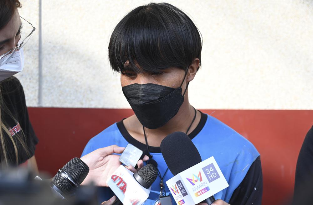 A Myanmar national identified as Song, one of two painters rescued from a high-rise condominium in Thailand, talks to reporters at Pak Kret police station in Nonthaburi near Bangkok, Wednesday. A resident of the building cut the support rope for the two painters, apparently angry she wasn't told they would be doing work, and left them hanging above the 26th floor until a couple rescued them, police said Wednesday. 
