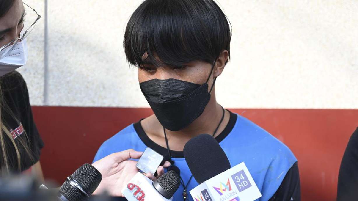 A Myanmar national identified as Song, one of two painters rescued from a high-rise condominium in Thailand, talks to reporters at Pak Kret police station in Nonthaburi near Bangkok, Wednesday. A resident of the building cut the support rope for the two painters, apparently angry she wasn't told they would be doing work, and left them hanging above the 26th floor until a couple rescued them, police said Wednesday.