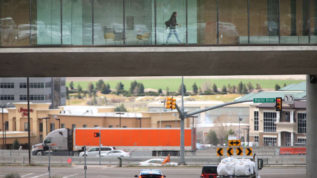 An Adobe employee walks through the office as traffic moves below in Lehi on March 23, 2016. Utah leaders held a summit at Utah Valley University on Thursday to discuss the growth in Utah County and strategies for making sure Utah County continues to be a place people want to come to live and grow their businesses.