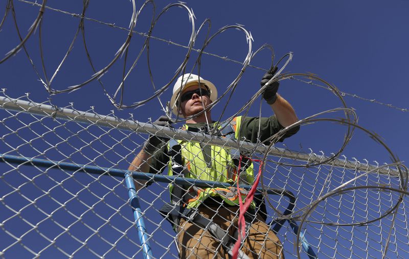 Max Beazer, American Fence installer, puts up razor
wire around the new Utah State Prison in Salt Lake City on
Thursday, Oct. 21.