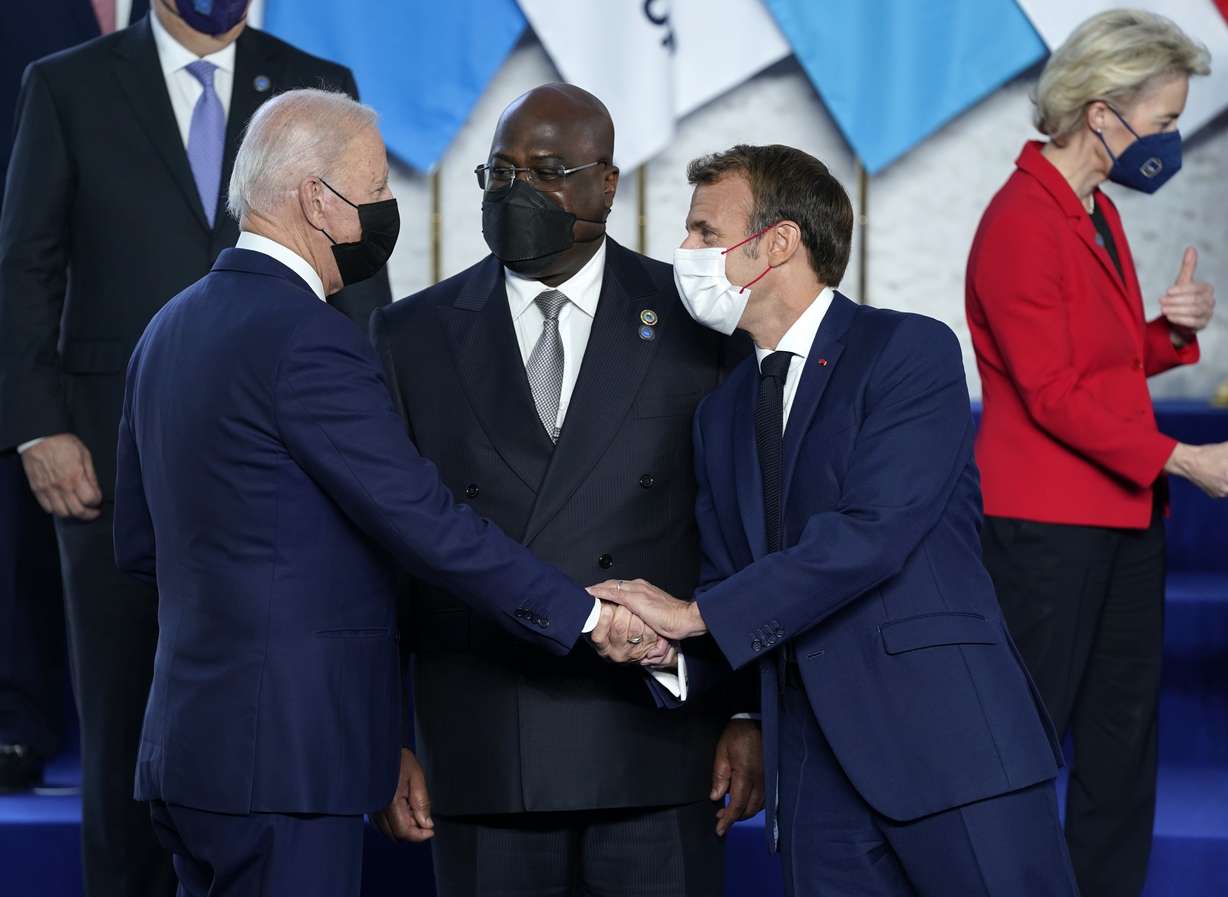U.S. President Joe Biden, left, greets French President Emmanuel Macron, second right, during a group photo at the G20 summit in Rome, Saturday, Oct. 30, 2021. The two-day Group of 20 summit is the first in-person gathering of leaders of the world's biggest economies since the COVID-19 pandemic started.