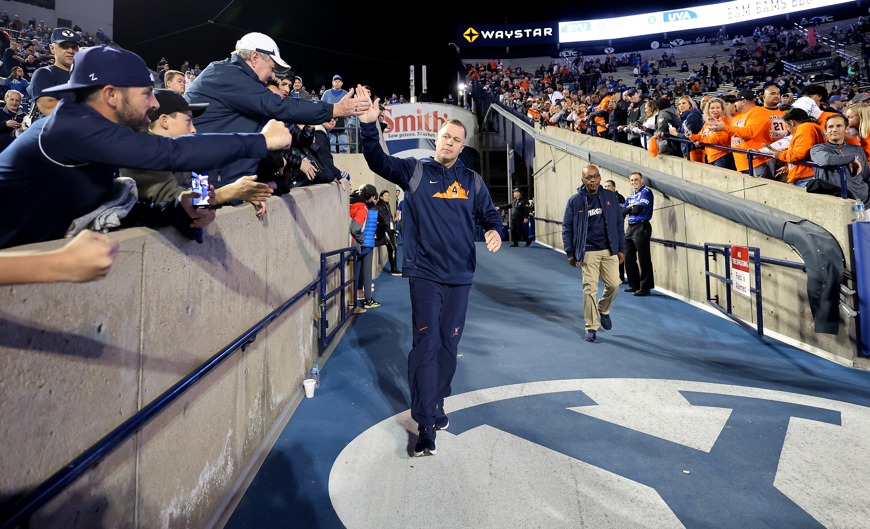 Virginia Cavaliers head coach Bronco Mendenhall high-fives fans as he enters the stadium as BYU and Virginia prepare to play at LaVell Edwards Stadium in Provo on Saturday, Oct. 30, 2021.