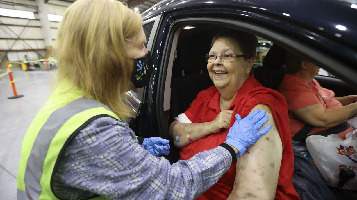 Davis County Community Health nurse Debbie Patton gives Christine Cunningham, of Farmington, a COVID-19 booster shot at the Legacy Events Center in Farmington on Oct. 25. Utah health officials confirmed 1,122 new COVID-19 cases on Tuesday, as well as 11 additional deaths.