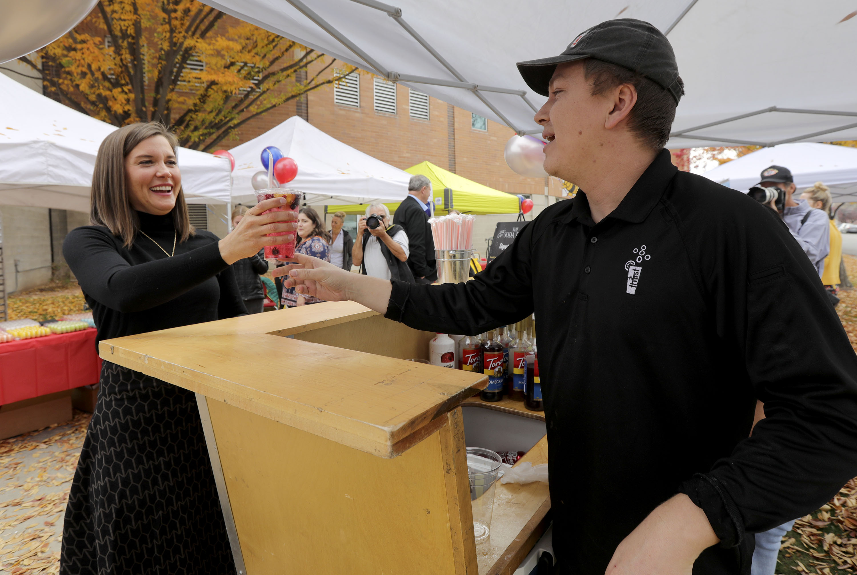 Salt Lake City Mayor Erin Mendenhall, left, gets a spa water from Thirst owner Ethan Cisneros during a press conference to announce new plans for the Ballpark neighborhood in Salt Lake City on Monday.