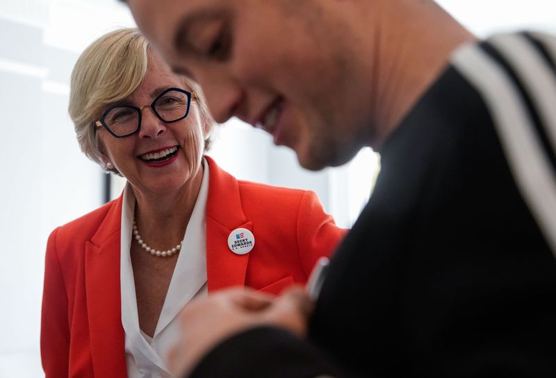 Republican Senate candidate Becky Edwards looks toward
Encircle House Chief Operating Officer Jacob Donford as he puts on
a campaign badge while touring Encircle House on Thursday, Oct. 28,
2021 in Salt Lake City.
