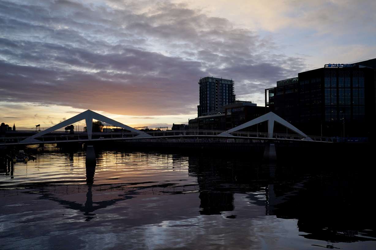 The sun begins to rise over the River Clyde outside the venue of the COP26 U.N. Climate Summit in Glasgow, Scotland, Tuesday, Nov. 2, 2021.