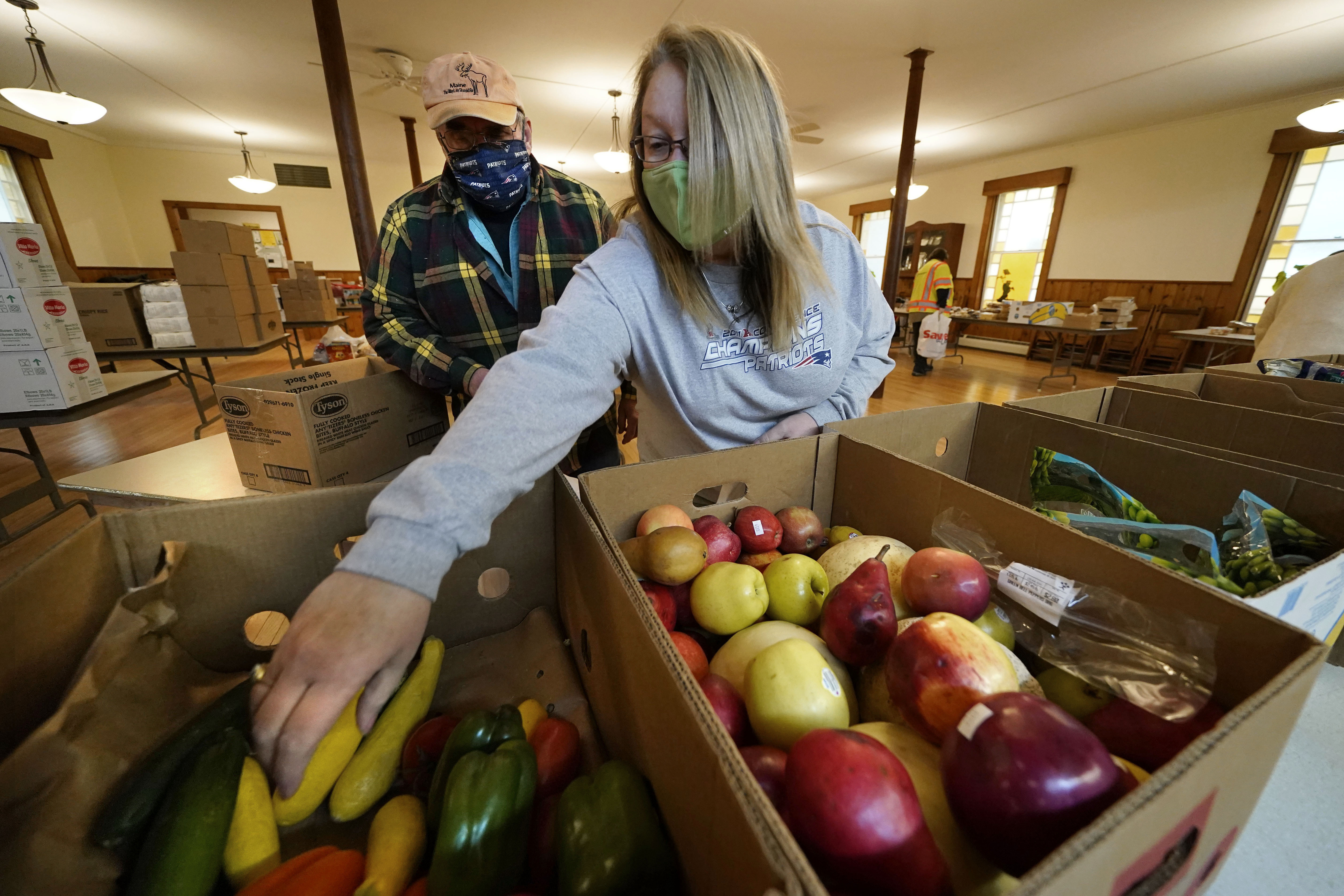 Volunteers Holly Roberts, right, and Terry Lord pick fruit to be bagged and given away at a food pantry at the First Universalist Church in Norway, Maine on Nov. 25, 2020. Voters in several states on Tuesday will decide whether to create new constitutional rights for people to grow food, gather in worship, vote early and visit loved ones in nursing homes. Among two dozen ballot measures in six states were several rebuking or affirming policies enacted during the coronavirus pandemic.