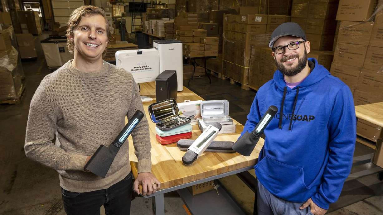 Dan Barnes, president and co-founder of PhoneSoap, and
Wes Laporte, the company’s CEO and co-founder, pose for photos with
their newest product, the SurfaceSoap UV Wand, a portable,
hand-held device that disinfects hard surfaces with
bacteria-killing ultraviolet light, inside the company’s warehouse
in Provo on Tuesday.