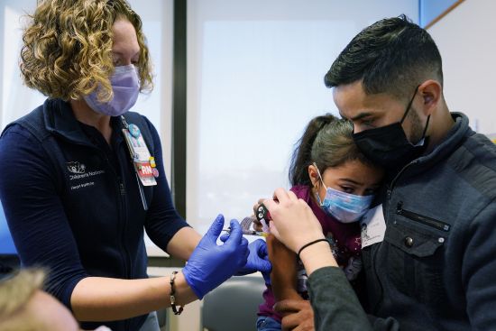 Kidney transplant patient Sophia Silvaamaya, 5, held by her father Pedro Silvaamaya, is vaccinated by nurse Kelly Vanderwende, Wednesday, at Children's National Hospital in Washington.