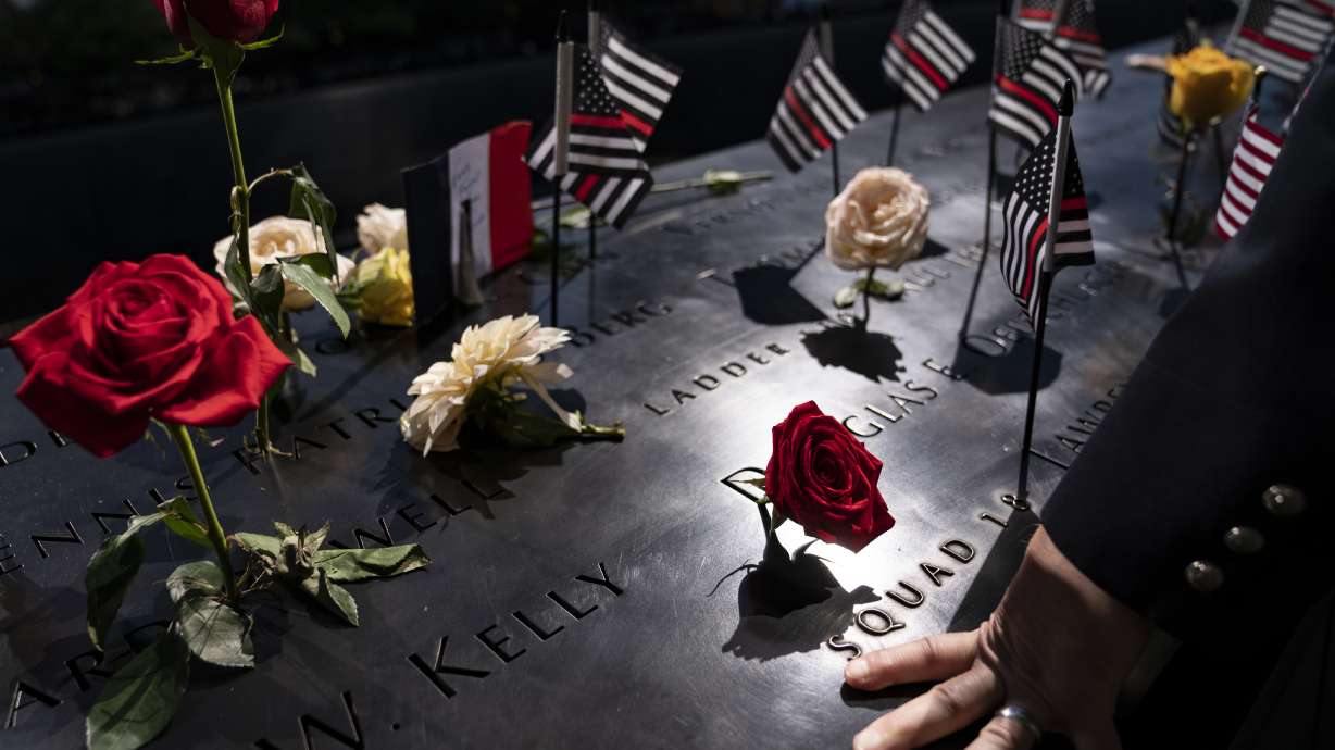 A firefighter places his hand on the name engravings on the south pool during ceremonies to commemorate the 20th anniversary of the Sept. 11 terrorist attacks, Sept. 11, 2021, at the National September 11 Memorial & Museum in New York. The FBI released hundreds of pages of newly declassified documents Wednesday about its long effort to explore connections between the Saudi government and the Sept. 11 attacks.