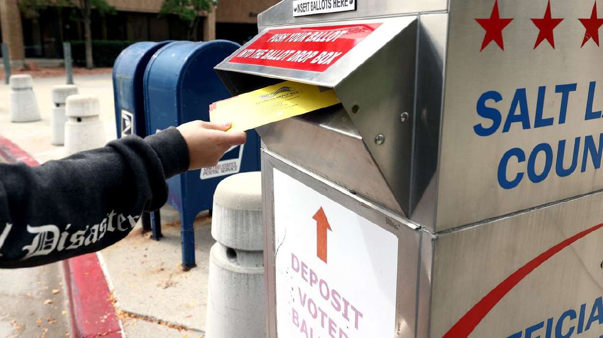 A voter drops a ballot into a box at the Salt Lake
County Government Center in Salt Lake City on Oct. 18.