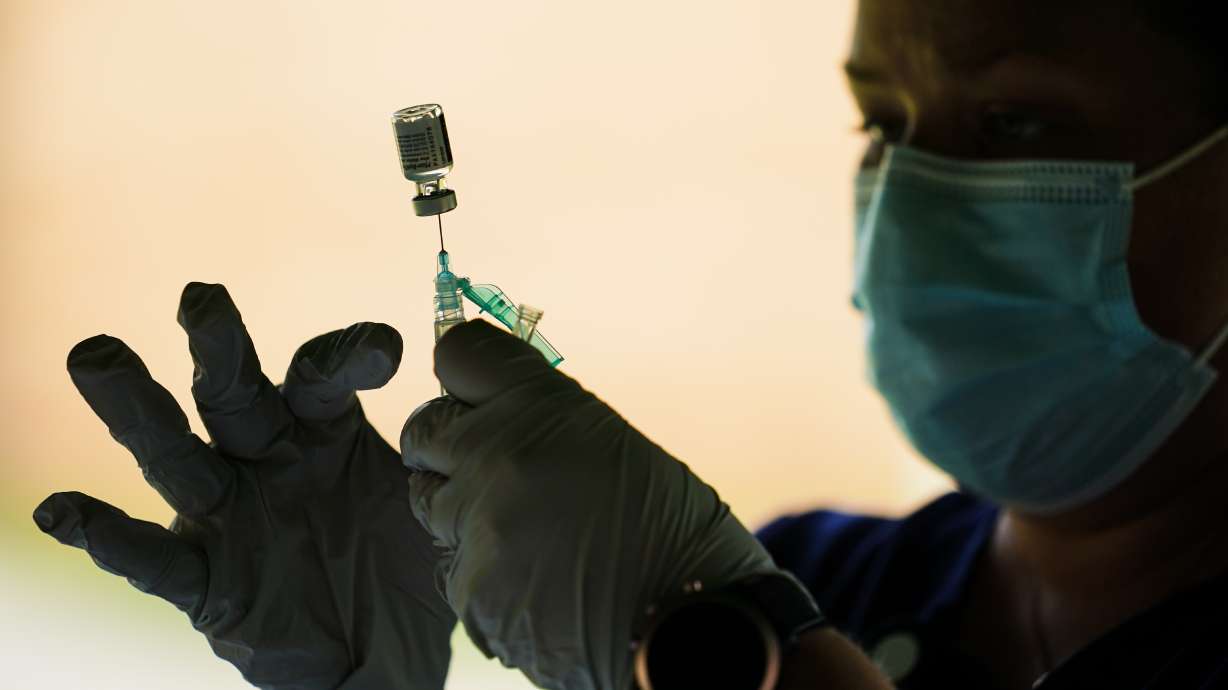 A syringe is prepared with the Pfizer COVID-19 vaccine in Reading, Pa. in September. Tens of millions of Americans who work at companies with 100 or more employees will need to be fully vaccinated against COVID-19 by Jan. 4 or get tested for the virus weekly, the government said Thursday.