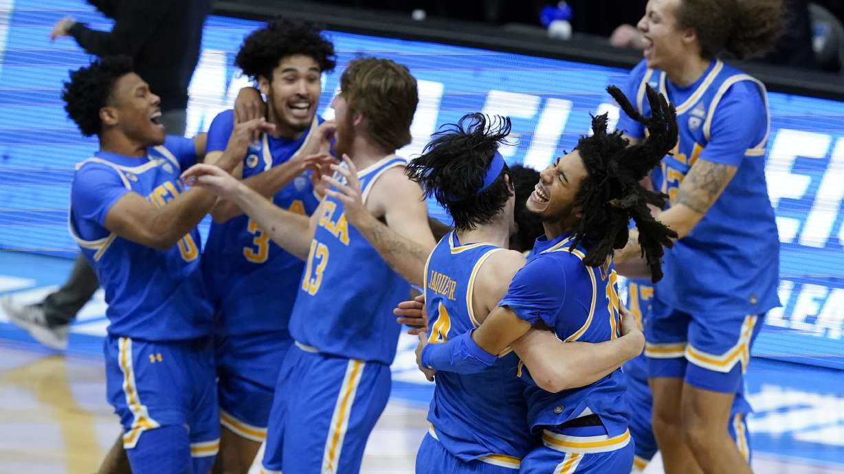 UCLA guard Tyger Campbell, right, celebrates with teammate guard Jaime Jaquez Jr. (4) after an Elite 8 game against Michigan in the NCAA men's college basketball tournament at Lucas Oil Stadium, in Indianapolis, Wednesday, March 31, 2021.