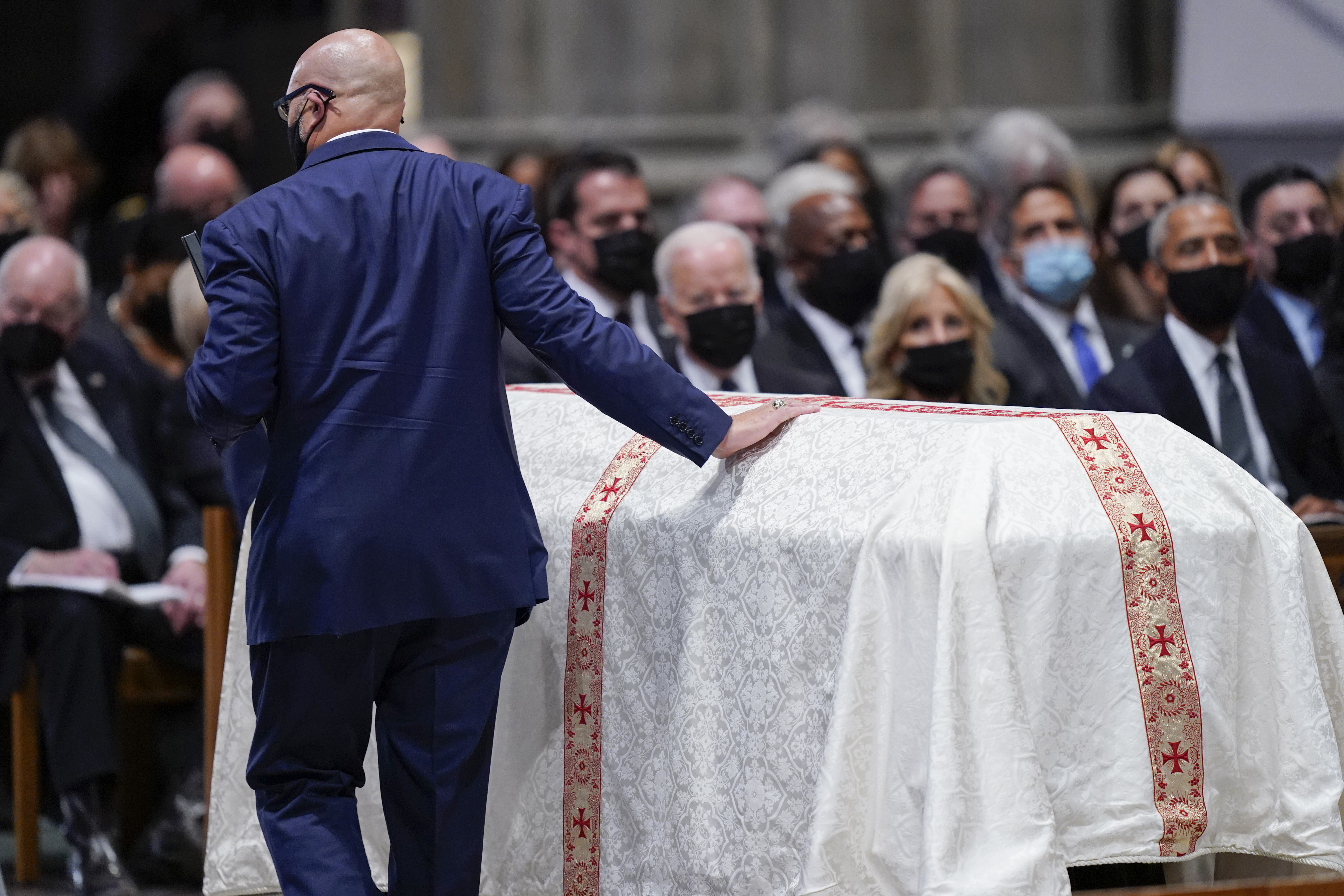 Michael Powell touches the casket of his father, former Secretary of State Colin Powell, during a funeral service at the Washington National Cathedral, Friday, in Washington.