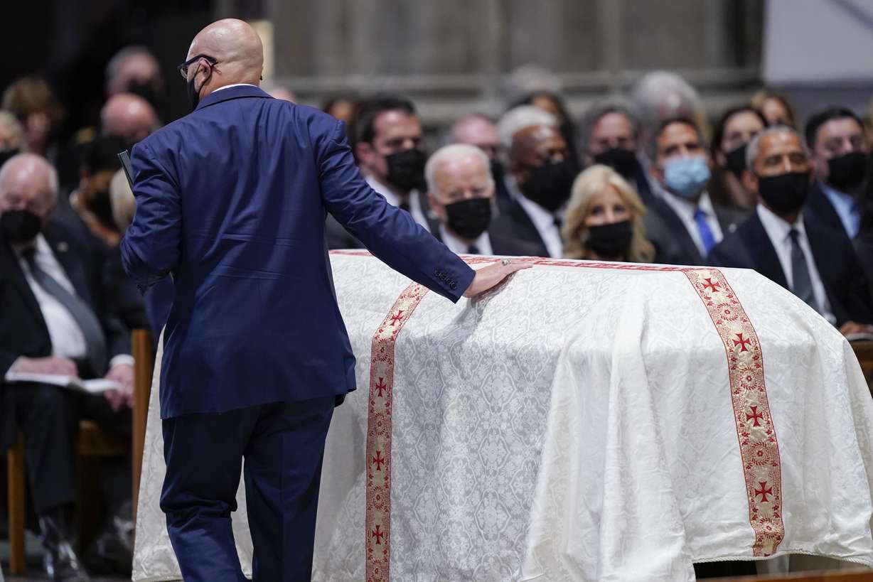 Michael Powell touches the casket of his father, former Secretary of State Colin Powell, during a funeral service at the Washington National Cathedral, Friday, in Washington.