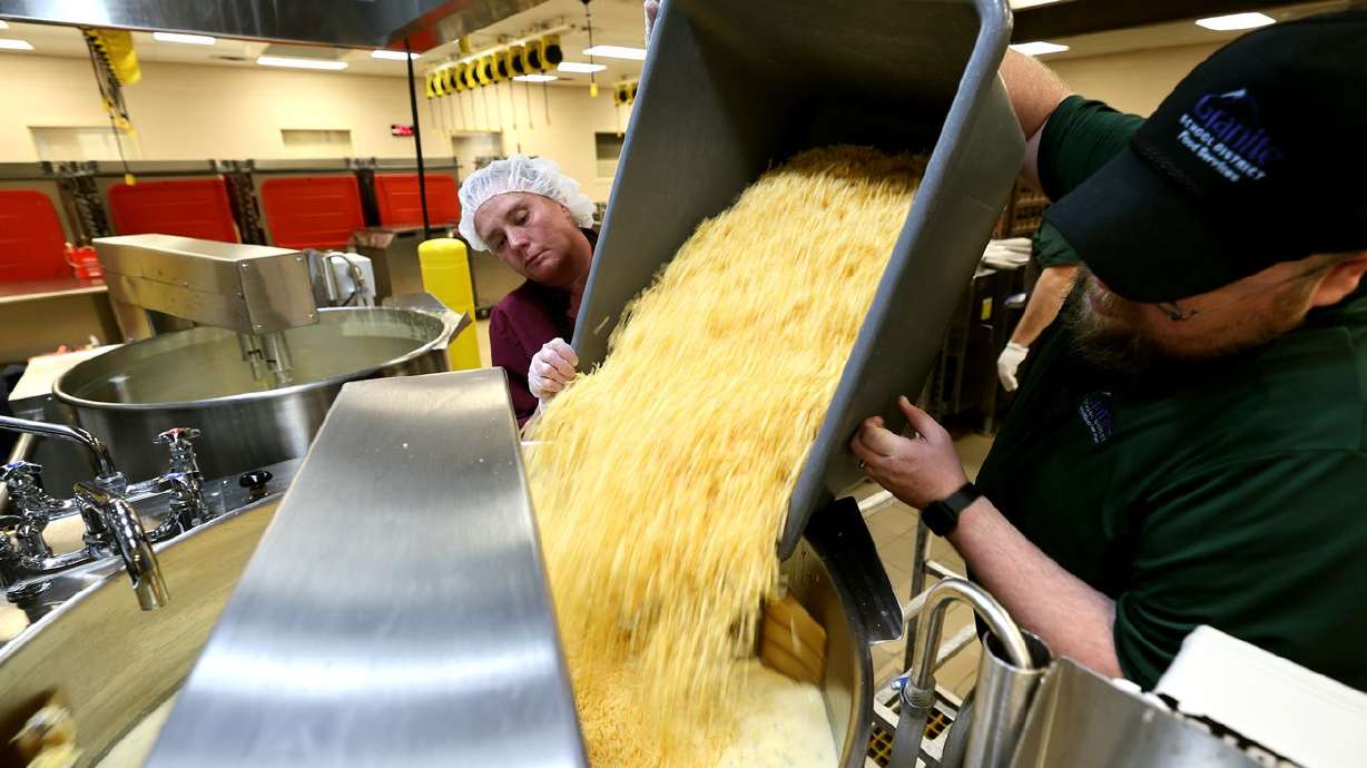 Workers dump cheese into a vat as they make cheese
sauce at Bates Central Kitchen, the Granite School
District’s central kitchen and warehouse, in West Valley City on
Friday.