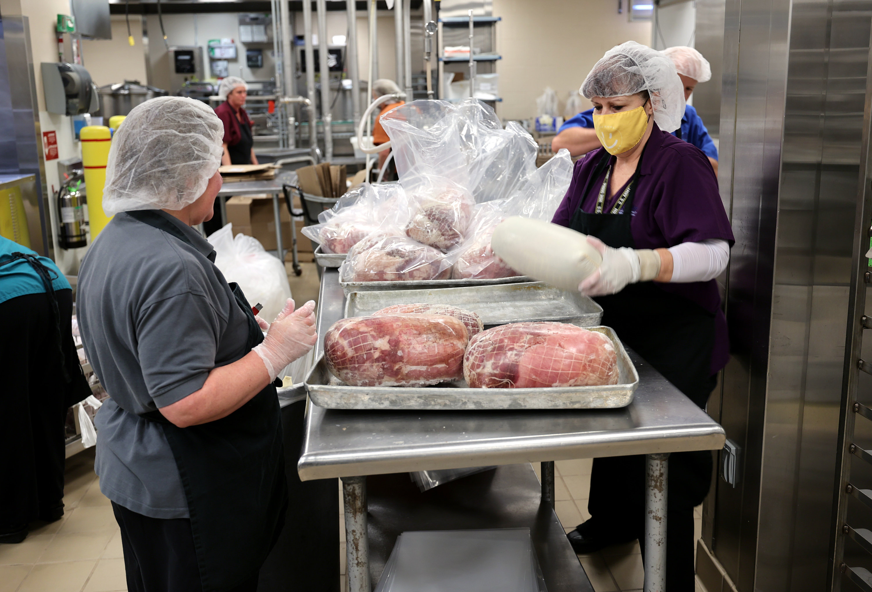 Workers process food for schools at Bates Central Kitchen, the Granite School District's central kitchen and warehouse, in West Valley City on Friday.