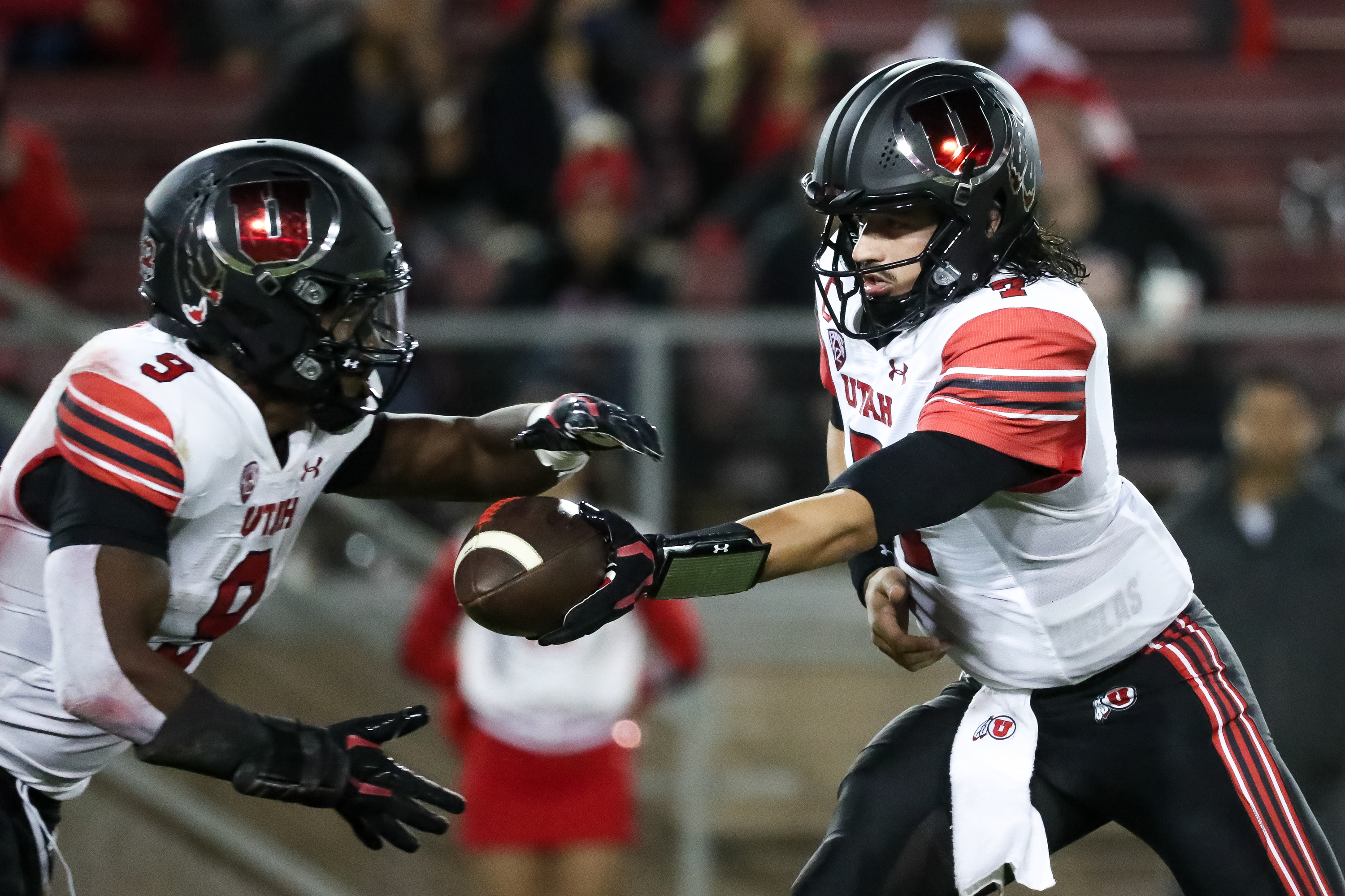 Utah Utes quarterback Cameron Rising (7) hands the ball off the running back Tavion Thomas (9) during the game against the Stanford Cardinal in Stanford, Calif. on Friday, Nov. 5, 2021.