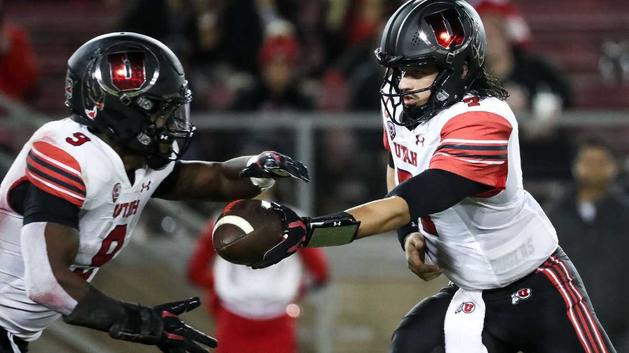Utah Utes quarterback Cameron Rising (7) hands the ball off the running back Tavion Thomas (9) during the game against the Stanford Cardinal in Stanford, Calif. on Friday, Nov. 5, 2021.
