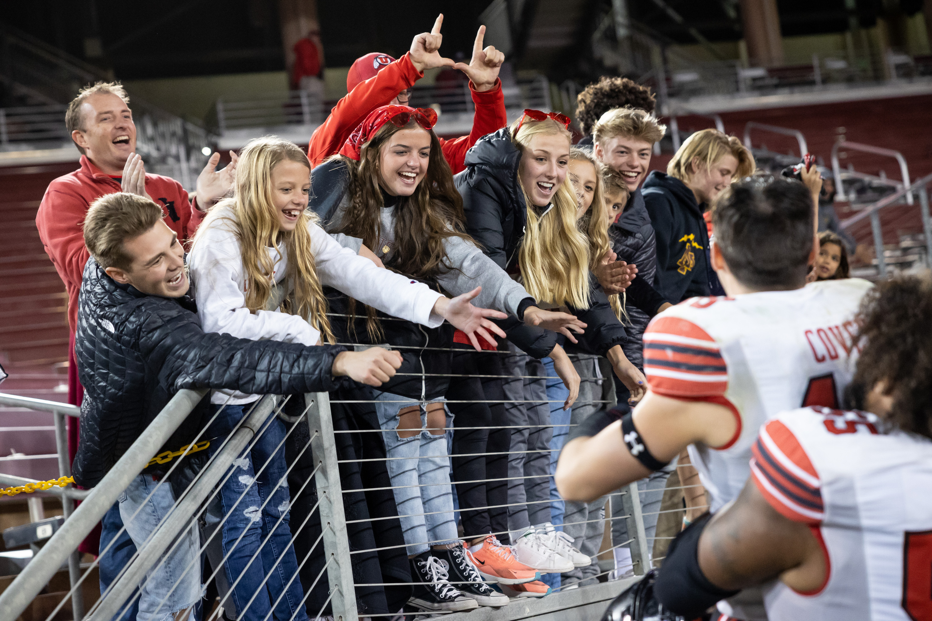 Utah Utes fans cheer as Utah Utes offensive lineman Nick Ford (55) lifts wide receiver Britain Covey (18) after the game against the Stanford Cardinal in Stanford, Calif. on Friday, Nov. 5, 2021.
