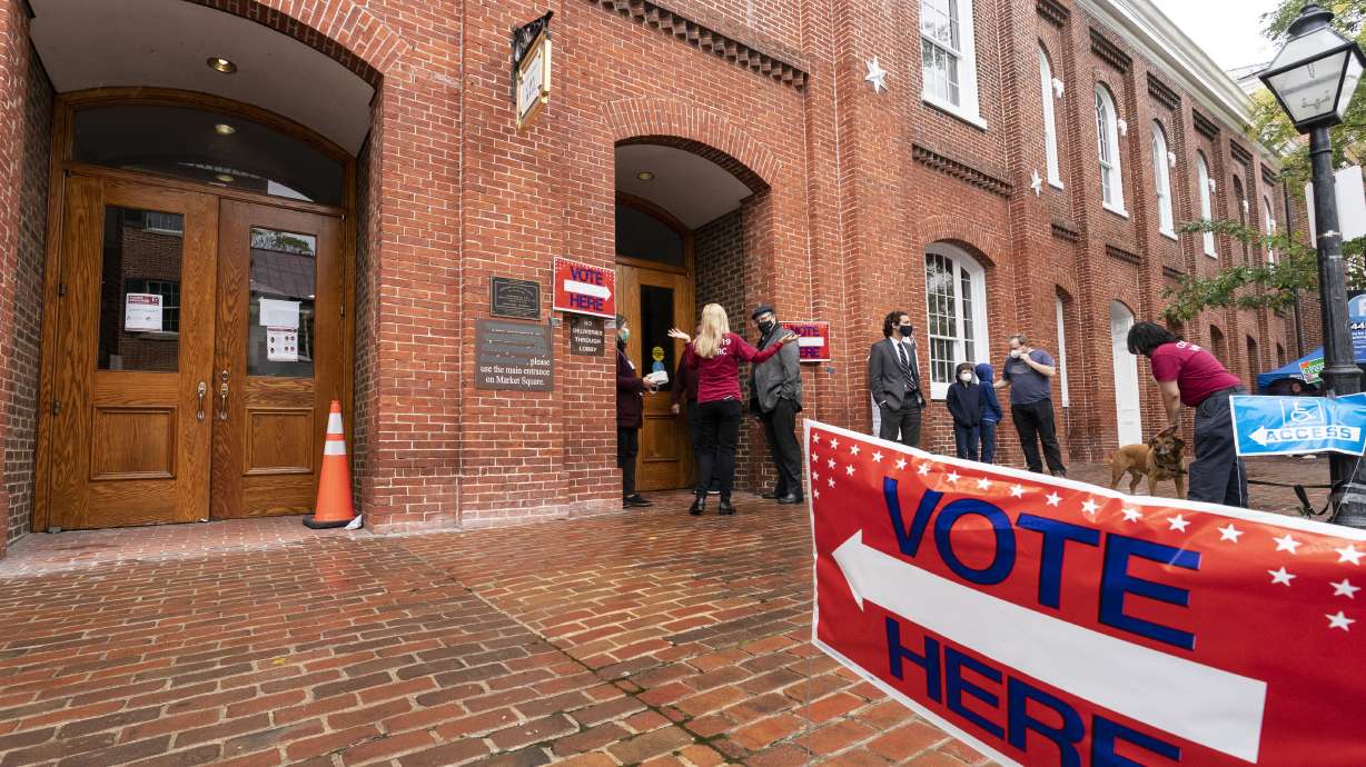 Voters arrive to cast their ballots on Election Day at City Hall, Tuesday, in Alexandria, Va.