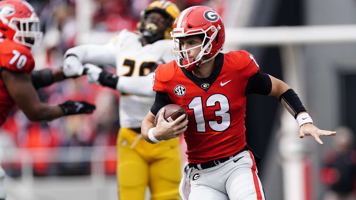 Georgia quarterback Stetson Bennett (13) looks for running room in the first half of an NCAA college football game against the Missouri Saturday, Nov. 6, 2021, in Athens, Ga..