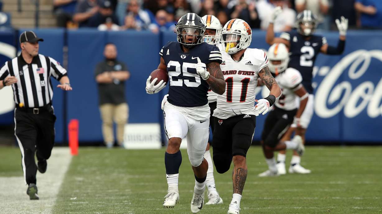 Brigham Young Cougars running back Tyler Allgeier (25) runs in the open field as Idaho State Bengals linebacker Oshea Trujillo (11) runs up from behind to make the touchdown saving tackle as BYU Cougars and the Idaho State Bengals play at LaVell Edwards Stadium in Provo on Saturday, Nov. 6, 2021.