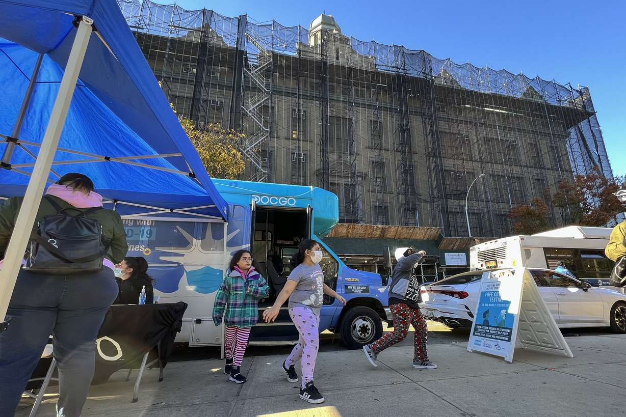 Children walk outside of a mobile vaccine unit after getting the first dose of their COVID-19 vaccine, outside P.S. 277, Friday, in the Bronx borough of New York.
