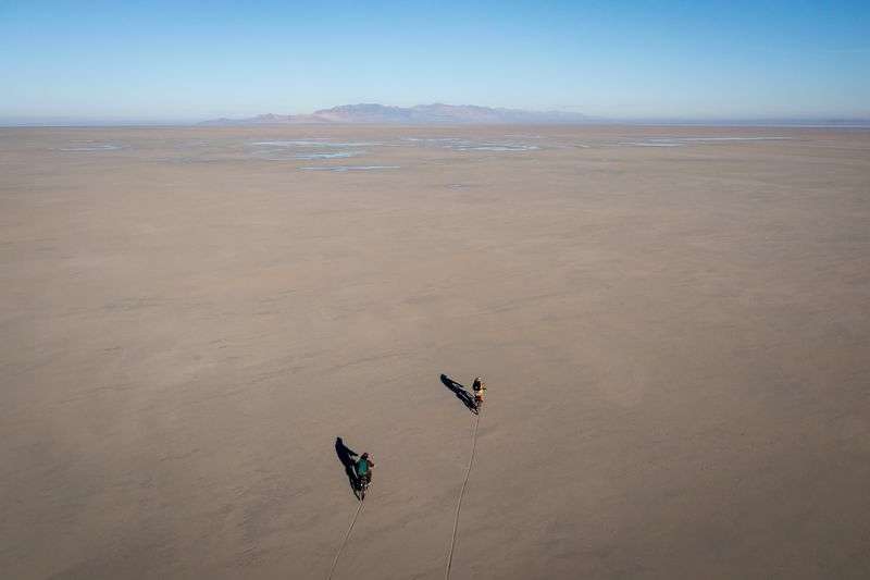 Marisa Weinberg, minerals and surface lease analyst for
the Utah Division of Forestry, Fire and State Lands, and Jason
Curry, the division’s deputy director, ride e-bikes across a
sandbar to Fremont Island on Thursday, Oct. 21.