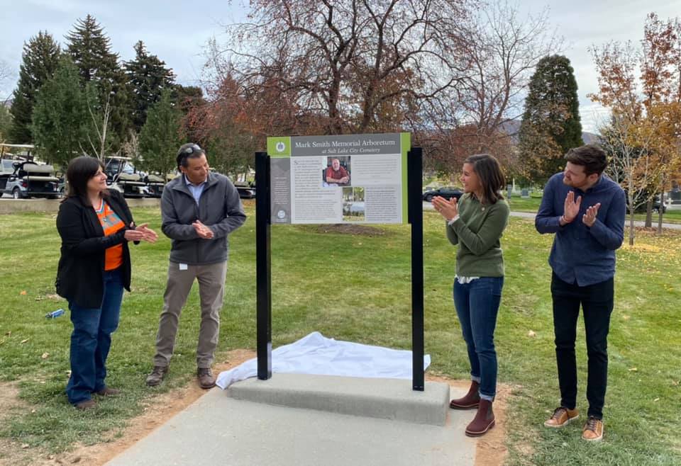 Julie Fratto-Smith, widow of Mark Smith, joins Salt Lake City officials in unveiling a new sign indicating the Mark Smith Memorial Arboretum at the Salt Lake City Cemetery on Saturday. Smith was the longest-serving sexton in the cemetery's history.