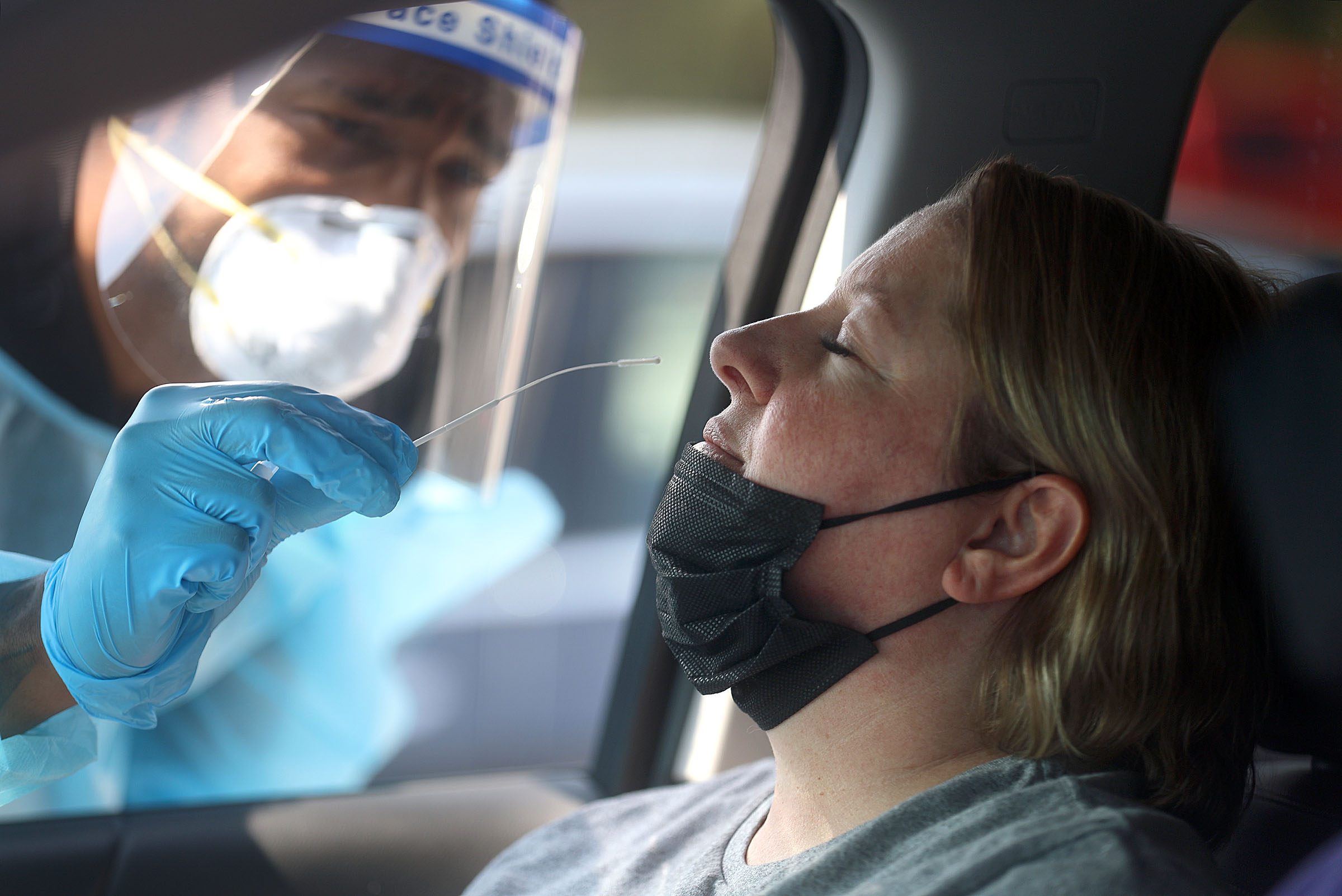 Frankie Coelho, a Nomi Health EMT, tests Angela Hiskey for COVID-19 outside of the Mount Olympus Senior Center in Millcreek on Sept. 7.