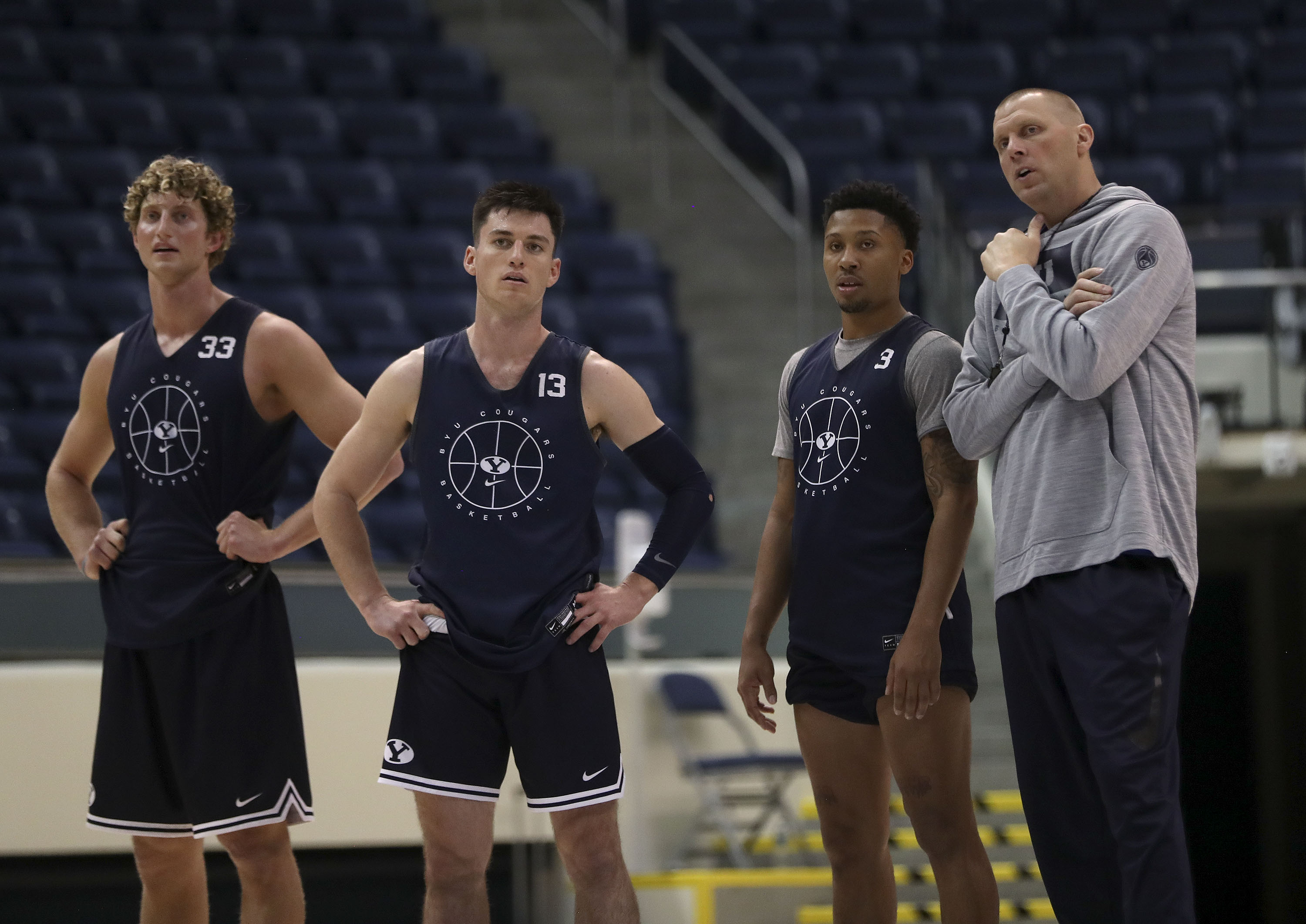 BYU’s Caleb Lohner, left, Alex Barcello, Te’Jon Lucas and Coach Mark Pope talk during practice at the Marriott Center in Provo on Thursday, Oct. 21, 2021.