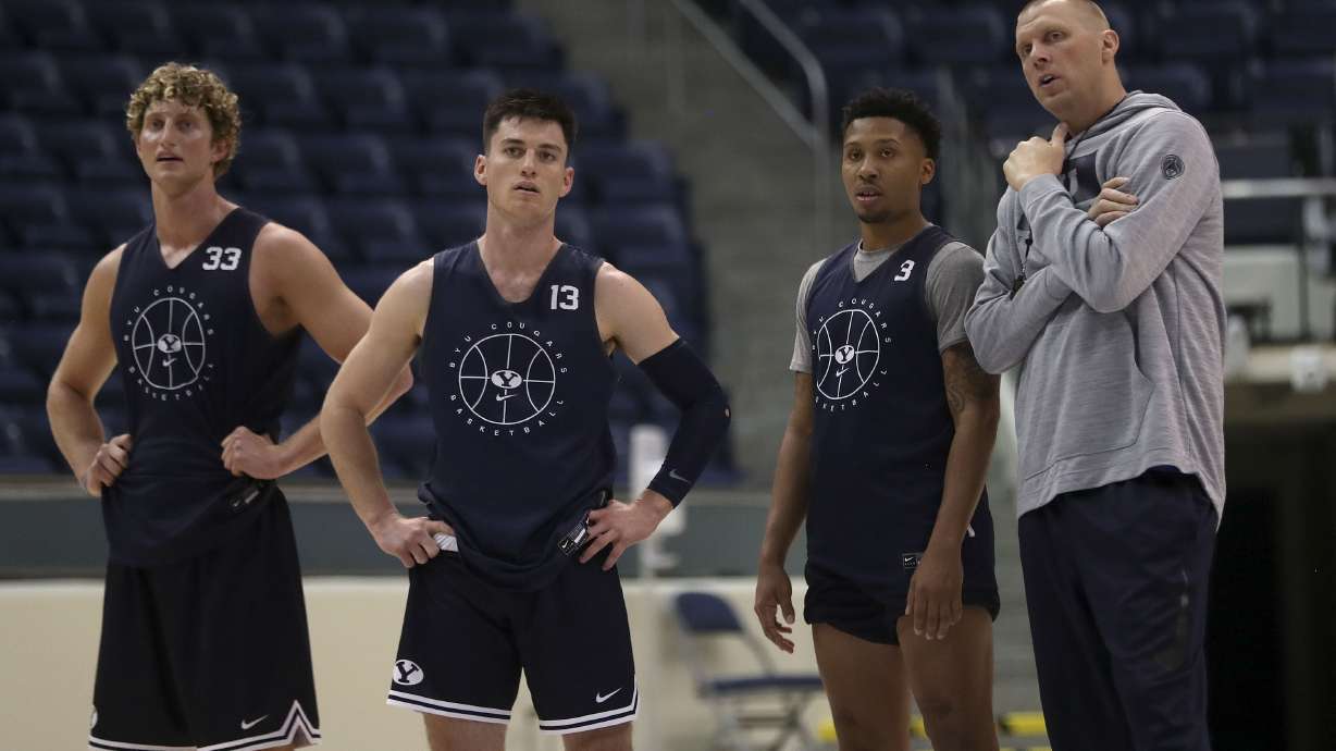 BYU’s Caleb Lohner, left, Alex Barcello, Te’Jon Lucas and Coach Mark Pope talk during practice at the Marriott Center in Provo on Thursday, Oct. 21, 2021.