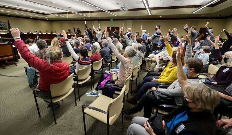 People raise their hands to signify they agree with
what speakers are saying during a Legislative Redistricting
Committee at the Capitol in Salt Lake City on Monday, Nov. 8,
2021.