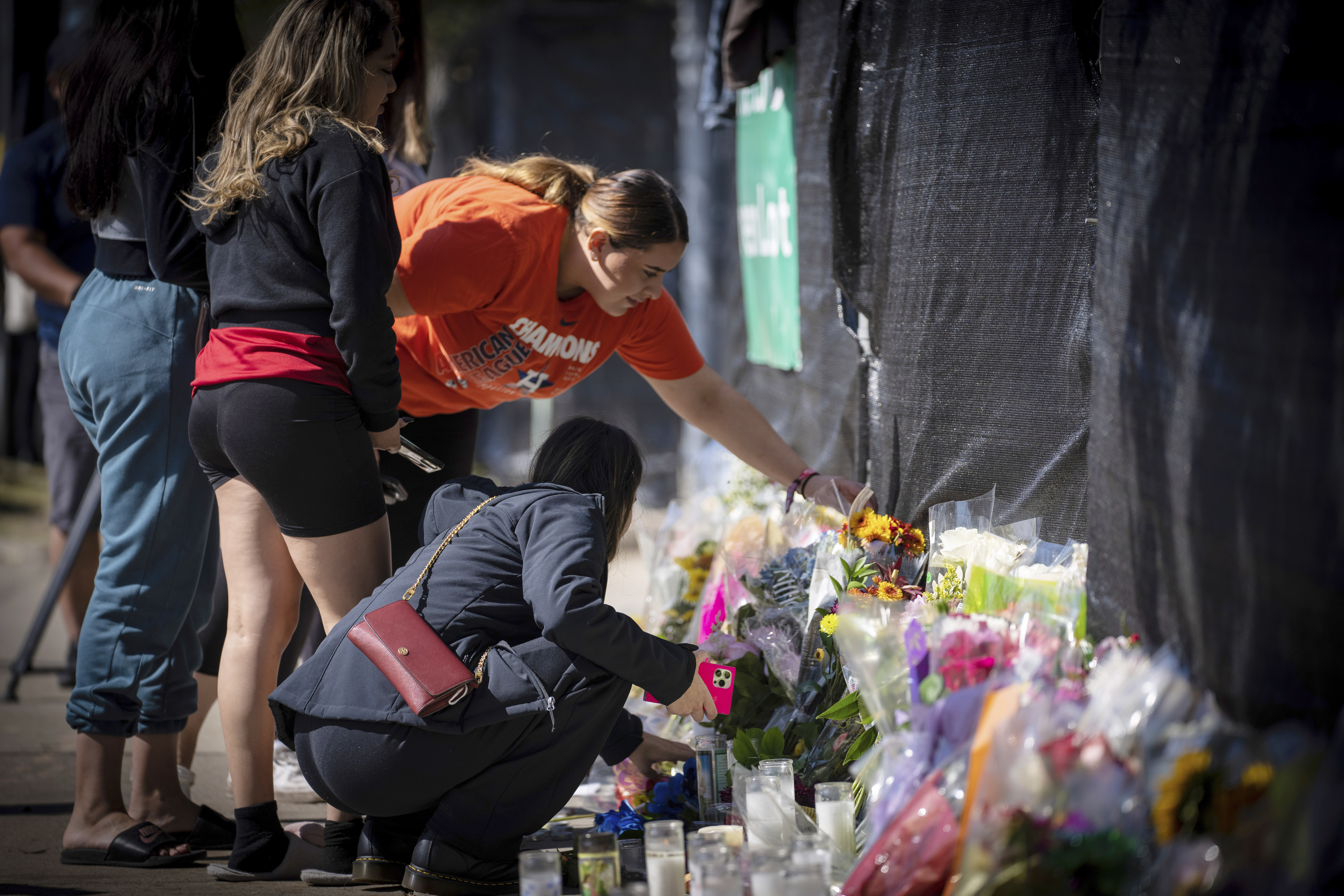 Stacey Sarmiento places flowers at a memorial in Houston on Sunday in memory of her friend who died in a crush of people at the Astroworld music festival on Friday.