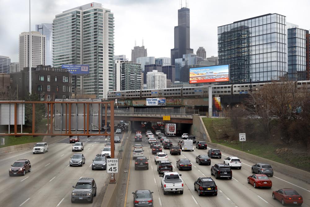Traffic flows along Interstate 90 highway as a Metra suburban commuter train moves along an elevated track in Chicago on March 31. Congress has created a new requirement for automakers: find a high-tech way to keep drunken people from driving cars. It's one of the mandates along with a burst of new spending aimed at improving auto safety amid escalating road fatalities in the $1 trillion infrastructure package that President Joe Biden is expected to sign soon.