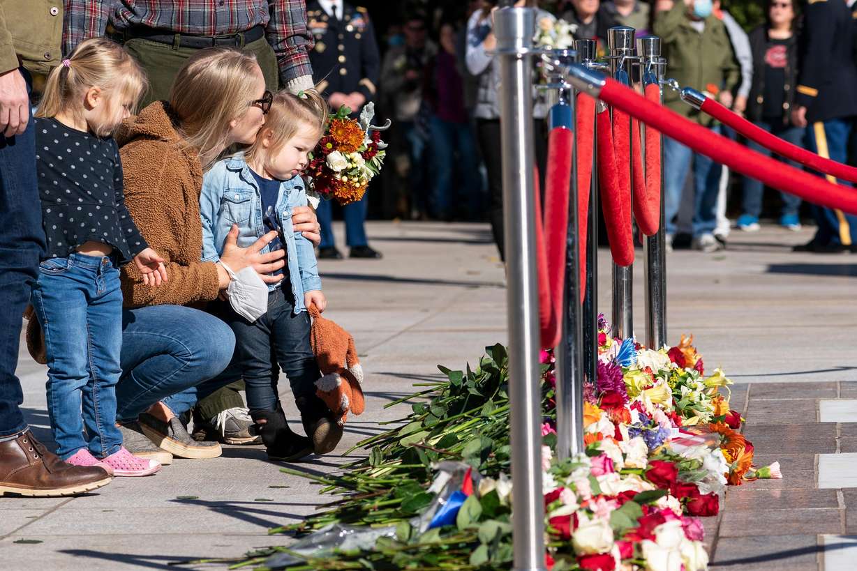 Stacy Wittmeyer, center, kisses her daughter Margaux Wittmeyer, 2, right, both from Springfield, Va., after placing a flower during a centennial commemoration event at the Tomb of the Unknown Soldier, in Arlington National Cemetery, Tuesday, in Arlington, Va.
