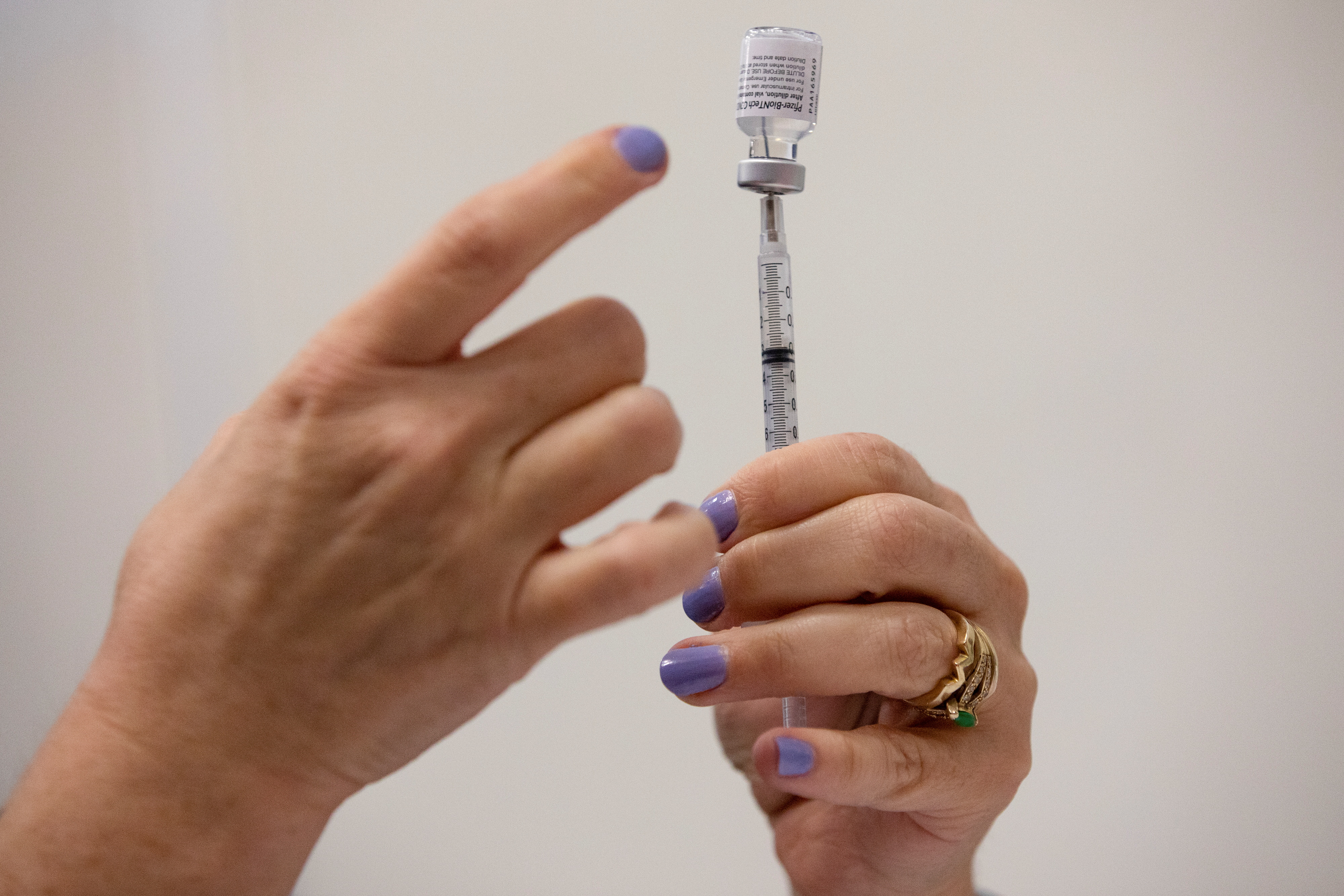 A nurse fills up syringes for patients as they receive their coronavirus disease booster vaccination during a Pfizer-BioNTech vaccination clinic in Southfield, Michigan, Sept. 29.  